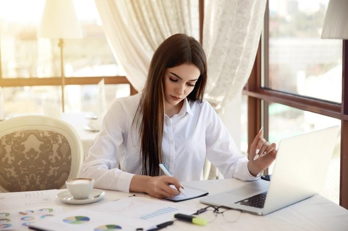 Woman reviewing her notes to learn vocabulary with sentence mining