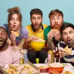 multiethnic-funny-companions-eat-popcorn-watch-horror-film-have-gaze-with-interest-express-surprisement-being-scared-frigthened-isolated-blue-wall-seated-comfortable-sofa-min-150x150.jpg