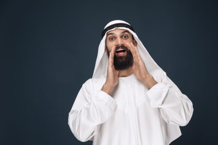 Man in Arabic clothes trying out his Arabic pronunciation