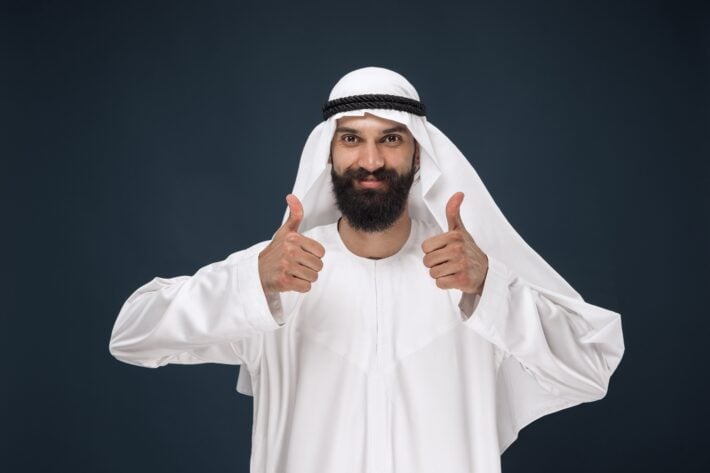 Man in Arabic clothes with his thumbs up, inviting you to learn Arabic pronunciation