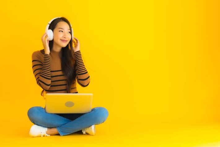 Young Asian woman learning with Korean podcasts on her computer